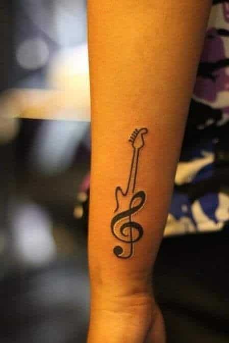 Guitar with music note on back of forearm tiny. 