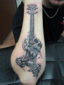 Skull inspired guitar strings tattoo.